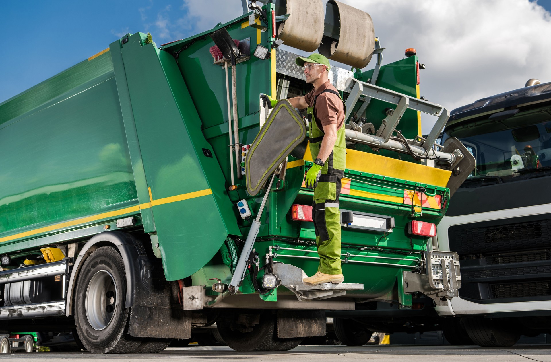 Caucasian Modern Garbage Truck Worker and the Vehicle.